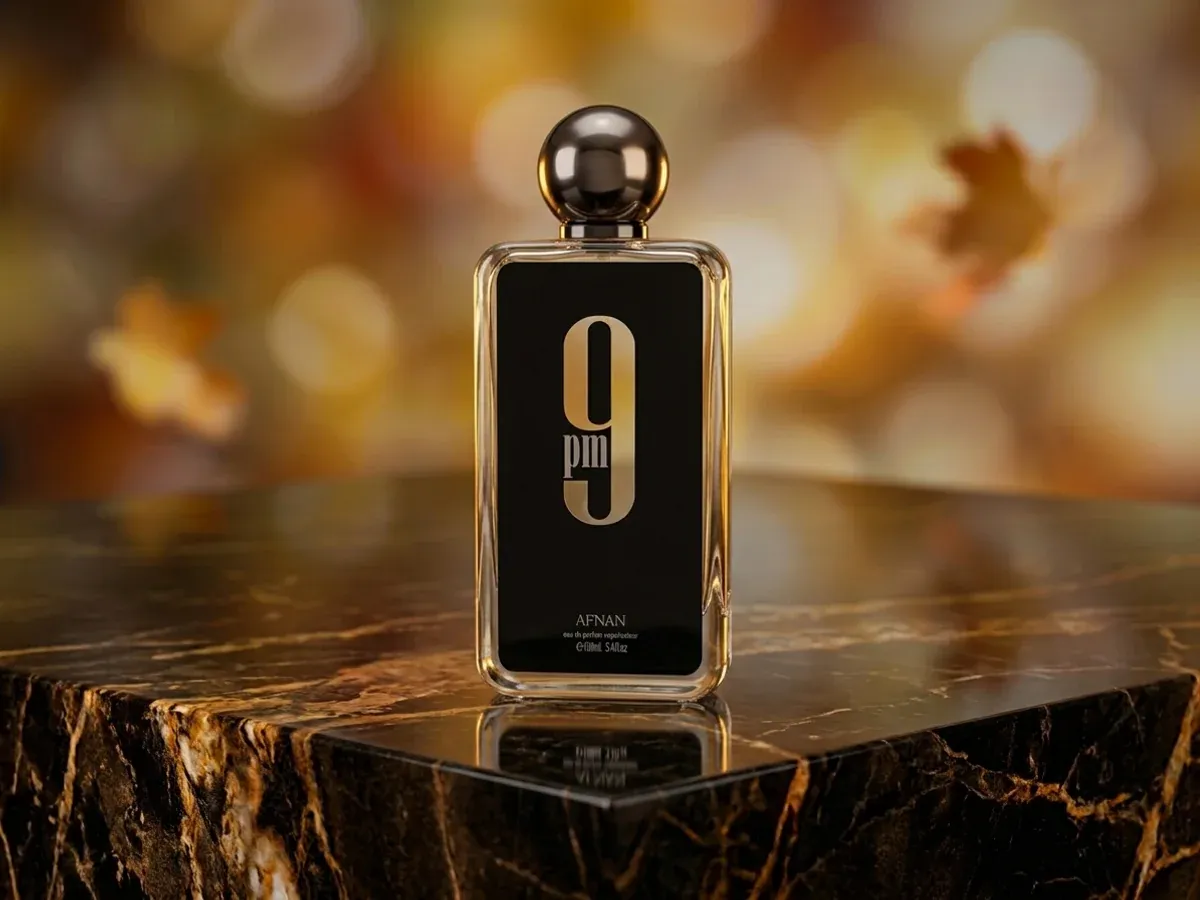 Bottle of Afnan 9PM on dark marble with autumn leaves