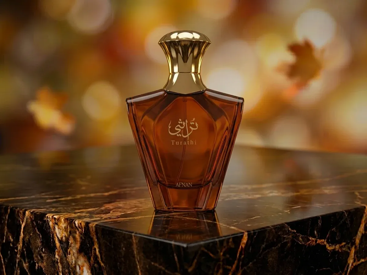 Bottle of Afnan Turathi Brown on dark marble with autumn leaves