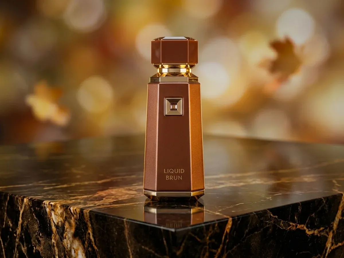 Bottle of French Avenue Liquid Brun on dark marble with autumn leaves