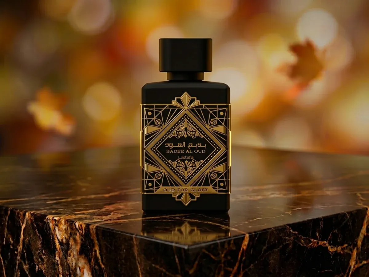 Bottle of Lattafa Bade'e Al Oud Oud for Glory on dark marble with autumn leaves