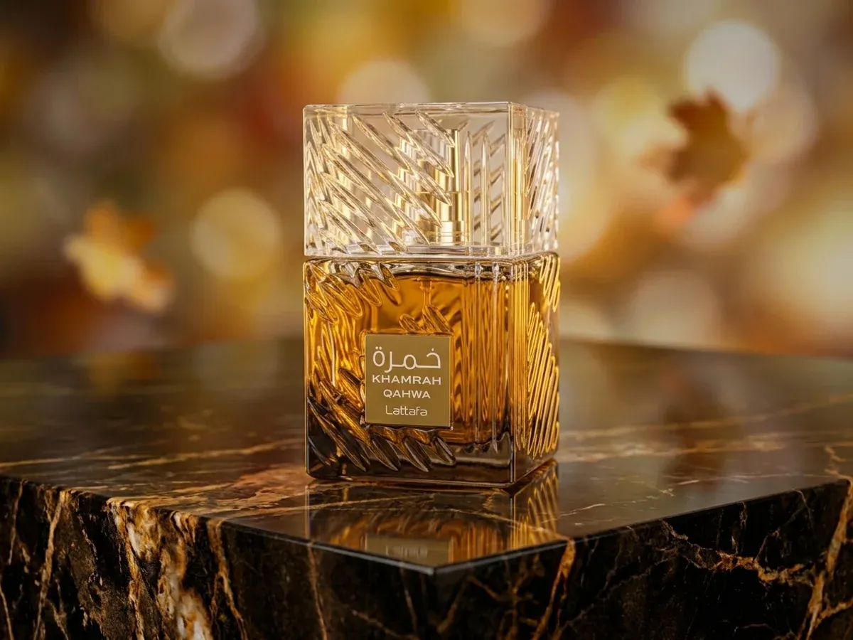 Bottle of Lattafa Khamrah Qahwa on dark marble with autumn leaves