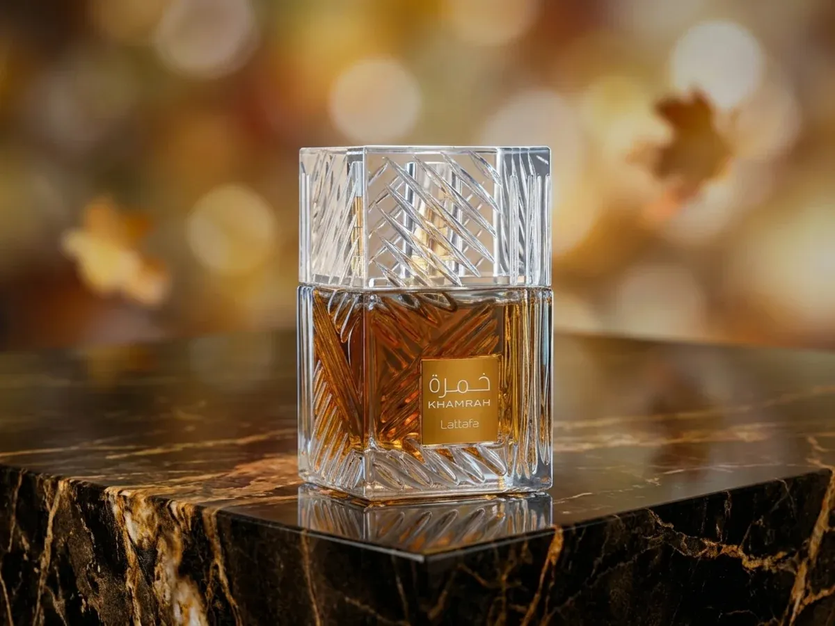 Bottle of Lattafa Khamrah on dark marble with autumn leaves